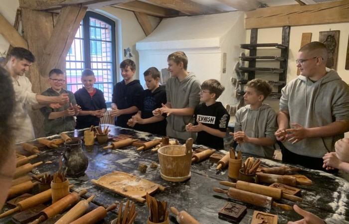 19 maja uczniowie klas 5a i 5b odwiedzili rodzinne miasto Mikołaja Kopernika. Zwiedzanie Torunia rozpoczęliśmy od Krzywej Wieży. Tutaj mogliśmy sprawdzić naszą prawość i uczciwość, gdyż według legendy tylko człowiek bez grzechu może utrzymać równowagę opierając się o jej ścianę. Następnie pan przewodnik oprowadził nas po Starym Mieście. Zobaczyliśmy dom i pomnik Mikołaja Kopernika, podziwialiśmy gotyckie kamienice, Bramę Klasztorną, Ratusz Staromiejski, Katedrę św. Jana Chrzciciela i św. Jana Ewangelisty. Poznaliśmy historię miasta i losy Mikołaja Kopernika. 
Kolejnym punktem programu było Żywe Muzeum Piernika. Pod okiem mistrza Dawida poznaliśmy rytuały związane z wypiekiem piernika. Własnoręcznie przygotowaliśmy ciasto i przy użyciu drewnianych form upiekliśmy pierniczki. Po warsztatach mieliśmy okazję zobaczyć manufakturę z początku XX wieku, maszyny służące do wypieku piernika, zabytkowy piec oraz kolekcję form woskowych.
Ostatnią atrakcją był Dom Legend Toruńskich. Tutaj nie tylko wysłuchaliśmy legend związanych z miastem, ale również sami mogliśmy wcielić się w ich bohaterów.
W drodze powrotnej zajechaliśmy do Grudziądza. Przeszliśmy Bramą Wodną na Stare Miasto i zrobiliśmy pamiątkową fotografię pod pomnikiem ułana i dziewczyny. 
To był udany dzień, pełen wrażeń. 