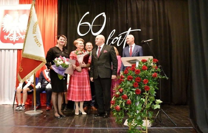 20 października świętowaliśmy Jubileusz 60-lecia Szkoły Podstawowej nr 2 w Pasłęku. Był to dla nas szczególny dzień, czas, w którym w symboliczny sposób przenieśliśmy się do chwili powstania naszej szkoły. Cieszymy się bardzo, że tak ważne dla nas wydarzenie swą obecnością uświetnili: minister Andrzej Śliwka - podsekretarz stanu w Ministerstwie Aktywów Państwowych, Burmistrz Pasłęka Pan Wiesław Śniecikowski, Przewodniczący Rady Miejskiej w Pasłęku Pan Marian Matuszczak, Starosta Powiatu Elbląskiego Pan Maciej Romanowski, wiceburmistrz Pan Marek Sarnowski, dyrektorzy i przedstawiciele instytucji oświatowych, służb mundurowych, działacze stowarzyszeń i związków zawodowych, emeryci oraz liczni absolwenci Szkoły Podstawowej nr 2 w Pasłęku.
Obchody jubileuszu rozpoczęliśmy od posadzenia drzewka przed pomnikiem patrona, Władysława Broniewskiego i przecięcia wstęgi na ławeczce upamiętniającej tę wyjątkową rocznicę. Następnie, już w auli, głos zabrała Pani Dyrektor Agnieszka Cieklińska, dzięki której wspomnienia związane z historią szkoły na nowo odżyły w pamięci zebranych. W pięknych słowach usłyszeliśmy o początkach szkoły, przypomnieliśmy sobie losy ludzi z nią związanych, ich sukcesy i zmagania, dzięki którym my dzisiaj możemy być częścią wyjątkowego miejsca, tak mocno wpisującego się w historię naszego miasta.