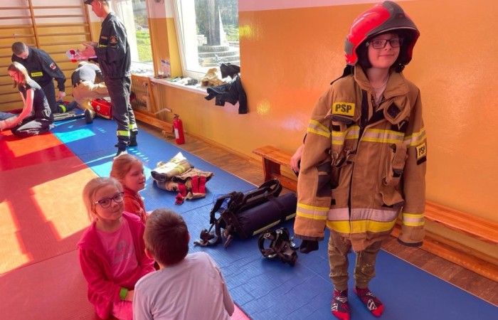 Wczoraj ponownie odwiedzili nas strażacy z OSP Marianka oraz JRG nr 3 w Pasłęku, którym towarzyszyły wolontariuszki z Zespołu Szkół w Pasłęku. Tym razem w spotkaniu uczestniczyli uczniowie klas drugich. Podczas szkolenia dzieci utrwaliły numer alarmowy 112, a także zapoznały się z całą procedurą zgłaszania wypadku i wzywania fachowej pomocy. Uczniowie dowiedzieli się co nieco na temat pracy strażaków, a także tego w jaki sposób opatruje się rany, złamania, udziela pierwszej pomocy, a co najważniejsze mieli okazję do przećwiczenia wszystkiego „na własnej skórze”. Jak widać po zdjęciach i tym razem dzieci były zachwycone. 
To była niezwykle istotna lekcja pomagająca poprzez zabawę i doświadczenia zdobywać nowe bardzo ważne informacje i umiejętności. 