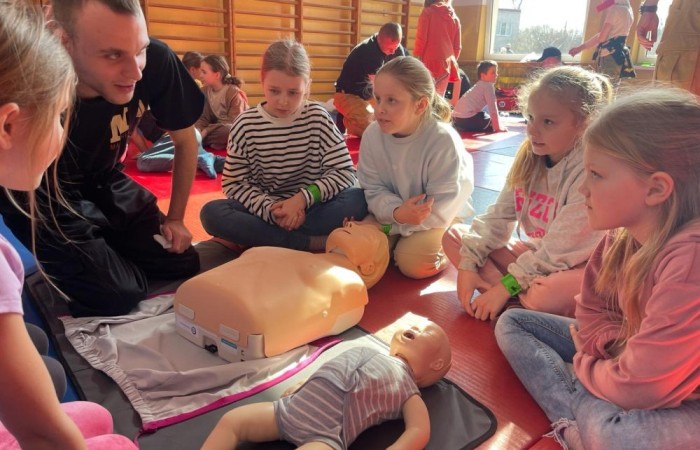 Wczoraj ponownie odwiedzili nas strażacy z OSP Marianka oraz JRG nr 3 w Pasłęku, którym towarzyszyły wolontariuszki z Zespołu Szkół w Pasłęku. Tym razem w spotkaniu uczestniczyli uczniowie klas drugich. Podczas szkolenia dzieci utrwaliły numer alarmowy 112, a także zapoznały się z całą procedurą zgłaszania wypadku i wzywania fachowej pomocy. Uczniowie dowiedzieli się co nieco na temat pracy strażaków, a także tego w jaki sposób opatruje się rany, złamania, udziela pierwszej pomocy, a co najważniejsze mieli okazję do przećwiczenia wszystkiego „na własnej skórze”. Jak widać po zdjęciach i tym razem dzieci były zachwycone. 
To była niezwykle istotna lekcja pomagająca poprzez zabawę i doświadczenia zdobywać nowe bardzo ważne informacje i umiejętności. 