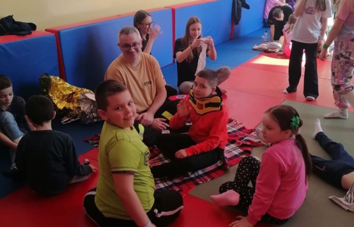 Wczoraj ponownie odwiedzili nas strażacy z OSP Marianka oraz JRG nr 3 w Pasłęku, którym towarzyszyły wolontariuszki z Zespołu Szkół w Pasłęku. Tym razem w spotkaniu uczestniczyli uczniowie klas drugich. Podczas szkolenia dzieci utrwaliły numer alarmowy 112, a także zapoznały się z całą procedurą zgłaszania wypadku i wzywania fachowej pomocy. Uczniowie dowiedzieli się co nieco na temat pracy strażaków, a także tego w jaki sposób opatruje się rany, złamania, udziela pierwszej pomocy, a co najważniejsze mieli okazję do przećwiczenia wszystkiego „na własnej skórze”. Jak widać po zdjęciach i tym razem dzieci były zachwycone. 
To była niezwykle istotna lekcja pomagająca poprzez zabawę i doświadczenia zdobywać nowe bardzo ważne informacje i umiejętności. 