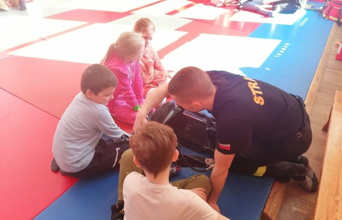 Wczoraj ponownie odwiedzili nas strażacy z OSP Marianka oraz JRG nr 3 w Pasłęku, którym towarzyszyły wolontariuszki z Zespołu Szkół w Pasłęku. Tym razem w spotkaniu uczestniczyli uczniowie klas drugich. Podczas szkolenia dzieci utrwaliły numer alarmowy 112, a także zapoznały się z całą procedurą zgłaszania wypadku i wzywania fachowej pomocy. Uczniowie dowiedzieli się co nieco na temat pracy strażaków, a także tego w jaki sposób opatruje się rany, złamania, udziela pierwszej pomocy, a co najważniejsze mieli okazję do przećwiczenia wszystkiego „na własnej skórze”. Jak widać po zdjęciach i tym razem dzieci były zachwycone. 
To była niezwykle istotna lekcja pomagająca poprzez zabawę i doświadczenia zdobywać nowe bardzo ważne informacje i umiejętności. 