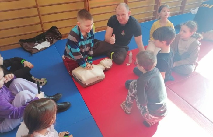 Wczoraj ponownie odwiedzili nas strażacy z OSP Marianka oraz JRG nr 3 w Pasłęku, którym towarzyszyły wolontariuszki z Zespołu Szkół w Pasłęku. Tym razem w spotkaniu uczestniczyli uczniowie klas drugich. Podczas szkolenia dzieci utrwaliły numer alarmowy 112, a także zapoznały się z całą procedurą zgłaszania wypadku i wzywania fachowej pomocy. Uczniowie dowiedzieli się co nieco na temat pracy strażaków, a także tego w jaki sposób opatruje się rany, złamania, udziela pierwszej pomocy, a co najważniejsze mieli okazję do przećwiczenia wszystkiego „na własnej skórze”. Jak widać po zdjęciach i tym razem dzieci były zachwycone. 
To była niezwykle istotna lekcja pomagająca poprzez zabawę i doświadczenia zdobywać nowe bardzo ważne informacje i umiejętności. 