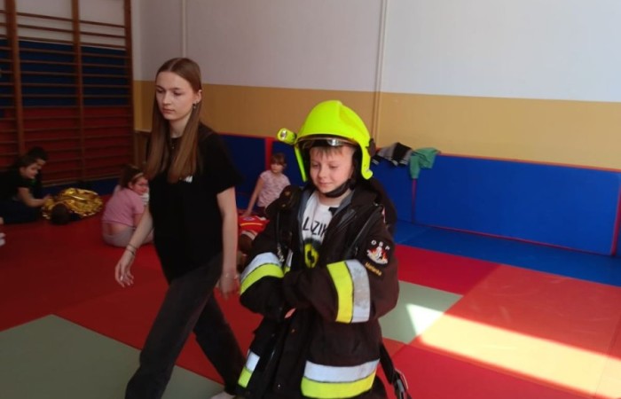 Za nami kolejne spotkanie ze strażakami z OSP Marianka, JRG 3 w Pasłęku oraz wolontariuszkami z Zespołu Szkół w Pasłęku w ramach akcji „Dzieci ratują życie”. Tym razem przyszła kolej na uczniów klas trzecich. Tradycyjnie już, nasi podopieczni mieli okazję do zgłębienia „tajników” pracy strażaków, utrwalenia numeru alarmowego, zasad postępowania podczas wzywania pomocy służb ratowniczych, a także udzielania pierwszej pomocy, opatrywania ran i złamań. Nie trzeba nikogo przekonywać, jak ważne jest przekazywanie wiedzy i kształtowanie praktycznych umiejętności w tym zakresie, na każdym etapie edukacji. 
Dzięki naszym wspaniałym gościom kształcimy małych ekspertów, którzy z pewnością będą wiedzieli jak zachować się w sytuacji zagrożenia.
