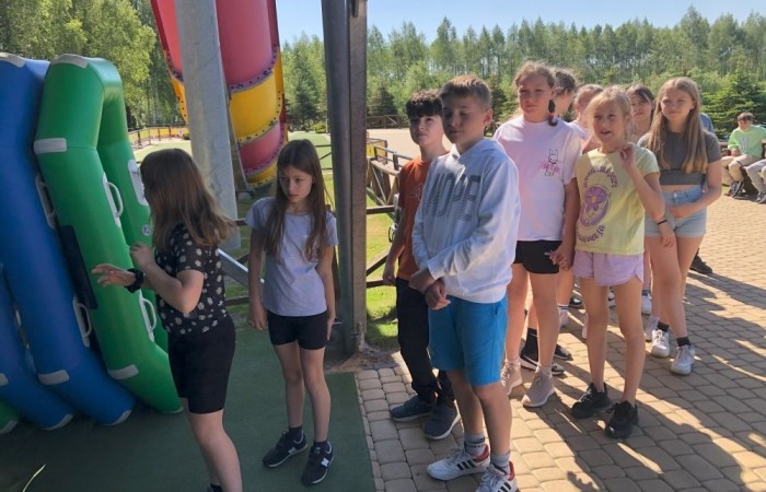 W dniach 15-18 maja 2024 roku uczniowie klas 4A i 5B wybrali się na wycieczkę do Łeby. Oto krótkie podsumowanie ich przygody.
Wizyta w Słowińskim Parku Narodowym była niezapomniana. Ruchome wydmy to unikalne miejsce, gdzie piaskowe pagórki przemieszczają się pod wpływem wiatru. Uczniowie mieli okazję spacerować po tych wydmach i podziwiać piękno natury.
W Łebie Parku czekało na nich wiele atrakcji: Zamek Strachu - dla odważnych, którzy lubią emocje; pojazdy Flinstonów - ciekawa atrakcja dla fanów kultowego serialu, Kopalnia złota - poszukiwanie skarbów; Labirynt magicznych luster - złudzenie nieskończonego lustra; zjeżdżalnie wodne 4 w 1 oraz zjeżdżalnia Boomerang - dla fanów wodnych atrakcji, zjazd na pontonach bez potrzeby przebierania się w stroje kąpielowe, wysokość ślizgu – 10 metrów; Diabelski Młyn, wysoki na 27 metrów wyposażony w 20 gondoli stoi nieopodal naszych zjeżdżalni, widok z góry zapiera dech w piersiach; park trampolin - ogromna przestrzeń, wypełniona parkourem, trampolinami, koszykówką, a także miejscem do robienia salt,  po których bezpiecznie wylądujesz na poduchę; autodrom - atrakcja którą zna niemal każdy! To must-have każdego parku rozrywki.
Uczniowie przemieszczali się po Łebie na melexach, co było wygodnym i ekscytującym środkiem transportu. Na koniec dnia uczniowie odpoczywali w Ośrodku Wypoczynkowym Fregata, gdzie mogli zrelaksować się po pełnym wrażeń dniu.
Wycieczka była udana, a uczniowie wrócili do domu z pięknymi wspomnieniami!