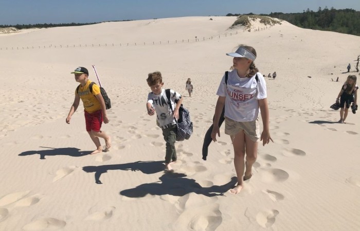 W dniach 15-18 maja 2024 roku uczniowie klas 4A i 5B wybrali się na wycieczkę do Łeby. Oto krótkie podsumowanie ich przygody.
Wizyta w Słowińskim Parku Narodowym była niezapomniana. Ruchome wydmy to unikalne miejsce, gdzie piaskowe pagórki przemieszczają się pod wpływem wiatru. Uczniowie mieli okazję spacerować po tych wydmach i podziwiać piękno natury.
W Łebie Parku czekało na nich wiele atrakcji: Zamek Strachu - dla odważnych, którzy lubią emocje; pojazdy Flinstonów - ciekawa atrakcja dla fanów kultowego serialu, Kopalnia złota - poszukiwanie skarbów; Labirynt magicznych luster - złudzenie nieskończonego lustra; zjeżdżalnie wodne 4 w 1 oraz zjeżdżalnia Boomerang - dla fanów wodnych atrakcji, zjazd na pontonach bez potrzeby przebierania się w stroje kąpielowe, wysokość ślizgu – 10 metrów; Diabelski Młyn, wysoki na 27 metrów wyposażony w 20 gondoli stoi nieopodal naszych zjeżdżalni, widok z góry zapiera dech w piersiach; park trampolin - ogromna przestrzeń, wypełniona parkourem, trampolinami, koszykówką, a także miejscem do robienia salt,  po których bezpiecznie wylądujesz na poduchę; autodrom - atrakcja którą zna niemal każdy! To must-have każdego parku rozrywki.
Uczniowie przemieszczali się po Łebie na melexach, co było wygodnym i ekscytującym środkiem transportu. Na koniec dnia uczniowie odpoczywali w Ośrodku Wypoczynkowym Fregata, gdzie mogli zrelaksować się po pełnym wrażeń dniu.
Wycieczka była udana, a uczniowie wrócili do domu z pięknymi wspomnieniami!