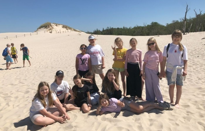 W dniach 15-18 maja 2024 roku uczniowie klas 4A i 5B wybrali się na wycieczkę do Łeby. Oto krótkie podsumowanie ich przygody.
Wizyta w Słowińskim Parku Narodowym była niezapomniana. Ruchome wydmy to unikalne miejsce, gdzie piaskowe pagórki przemieszczają się pod wpływem wiatru. Uczniowie mieli okazję spacerować po tych wydmach i podziwiać piękno natury.
W Łebie Parku czekało na nich wiele atrakcji: Zamek Strachu - dla odważnych, którzy lubią emocje; pojazdy Flinstonów - ciekawa atrakcja dla fanów kultowego serialu, Kopalnia złota - poszukiwanie skarbów; Labirynt magicznych luster - złudzenie nieskończonego lustra; zjeżdżalnie wodne 4 w 1 oraz zjeżdżalnia Boomerang - dla fanów wodnych atrakcji, zjazd na pontonach bez potrzeby przebierania się w stroje kąpielowe, wysokość ślizgu – 10 metrów; Diabelski Młyn, wysoki na 27 metrów wyposażony w 20 gondoli stoi nieopodal naszych zjeżdżalni, widok z góry zapiera dech w piersiach; park trampolin - ogromna przestrzeń, wypełniona parkourem, trampolinami, koszykówką, a także miejscem do robienia salt,  po których bezpiecznie wylądujesz na poduchę; autodrom - atrakcja którą zna niemal każdy! To must-have każdego parku rozrywki.
Uczniowie przemieszczali się po Łebie na melexach, co było wygodnym i ekscytującym środkiem transportu. Na koniec dnia uczniowie odpoczywali w Ośrodku Wypoczynkowym Fregata, gdzie mogli zrelaksować się po pełnym wrażeń dniu.
Wycieczka była udana, a uczniowie wrócili do domu z pięknymi wspomnieniami!