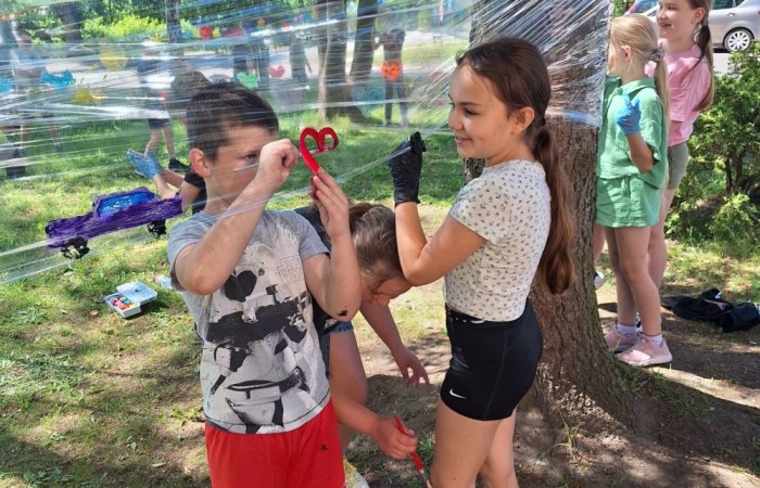 W ostatnim czasie uczniowie klasy III b wzięli udział w wyjątkowych zajęciach plastycznych, które wprawiły ich w zachwyt i radość tworzenia. Tym razem nasze artystyczne dusze miały okazję malować na świeżym powietrzu. Wyjątkowy pomysł na wykorzystanie folii spożywczej rozciągniętej pomiędzy drzewami okazał się strzałem w dziesiątkę. Uczniowie mogli wyrażać swoją kreatywność, eksperymentować z kolorami i formami, czerpiąc inspirację z natury otaczającej naszą szkołę.