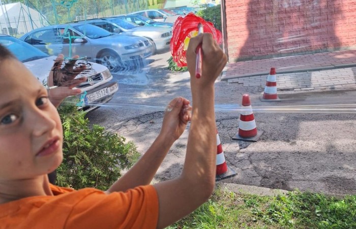 W ostatnim czasie uczniowie klasy III b wzięli udział w wyjątkowych zajęciach plastycznych, które wprawiły ich w zachwyt i radość tworzenia. Tym razem nasze artystyczne dusze miały okazję malować na świeżym powietrzu. Wyjątkowy pomysł na wykorzystanie folii spożywczej rozciągniętej pomiędzy drzewami okazał się strzałem w dziesiątkę. Uczniowie mogli wyrażać swoją kreatywność, eksperymentować z kolorami i formami, czerpiąc inspirację z natury otaczającej naszą szkołę.