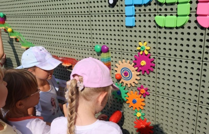 6 września w naszym przedszkolu miało miejsce oficjalne otwarcie “Kącika naukowo-kreatywnego” ufundowanego przez Polskie Sieci Elektroenergetyczne w ramach VI edycji programu “Wzmocnij Swoje Otoczenie”. Dzięki uzyskanemu grantowi w wysokości 22.112,00zł, Stowarzyszenie Przyjaciele Pasłęckiej Dwójki stworzyło najmłodszym uczniom SP nr 2 w Pasłęku kolorowe miejsce, w którym będą łączyć naukę z zabawą na świeżym powietrzu. Gry podwórkowe, ściany z namalowanymi bajkowymi postaciami, a także zakupione w ramach projektu tablice oraz dedykowane do nich kolorowe akcesoria z pewnością umilą przedszkolakom i dzieciom z klas I - III czas spędzony w placówce. Pozwolą również najmłodszym uczniom naszej szkoły odkrywać tajniki technologii, inżynierii, matematyki i fizyki w formie wesołej zabawy. 