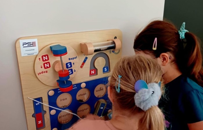 6 września w naszym przedszkolu miało miejsce oficjalne otwarcie “Kącika naukowo-kreatywnego” ufundowanego przez Polskie Sieci Elektroenergetyczne w ramach VI edycji programu “Wzmocnij Swoje Otoczenie”. Dzięki uzyskanemu grantowi w wysokości 22.112,00zł, Stowarzyszenie Przyjaciele Pasłęckiej Dwójki stworzyło najmłodszym uczniom SP nr 2 w Pasłęku kolorowe miejsce, w którym będą łączyć naukę z zabawą na świeżym powietrzu. Gry podwórkowe, ściany z namalowanymi bajkowymi postaciami, a także zakupione w ramach projektu tablice oraz dedykowane do nich kolorowe akcesoria z pewnością umilą przedszkolakom i dzieciom z klas I - III czas spędzony w placówce. Pozwolą również najmłodszym uczniom naszej szkoły odkrywać tajniki technologii, inżynierii, matematyki i fizyki w formie wesołej zabawy. 