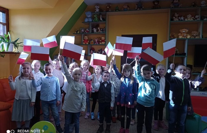 Dzieci z zerówki w bibliotece publicznej uczestniczyły w lekcji patriotyzmu przeprowadzonej przez dyrektora biblioteki p. Adamczyka. Lekcja przypomniała dzieciom symbole narodowe, poznały ciekawostki historyczne dotyczące pochodzenia tych symboli oraz ich znaczenia w historii Polski. Wspólnie odśpiewały fragment hymnu narodowego oraz wykonały flagę Polski.