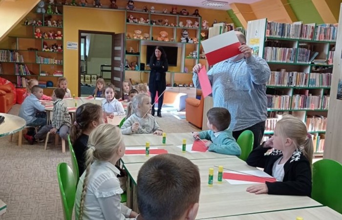 Dzieci z zerówki w bibliotece publicznej uczestniczyły w lekcji patriotyzmu przeprowadzonej przez dyrektora biblioteki p. Adamczyka. Lekcja przypomniała dzieciom symbole narodowe, poznały ciekawostki historyczne dotyczące pochodzenia tych symboli oraz ich znaczenia w historii Polski. Wspólnie odśpiewały fragment hymnu narodowego oraz wykonały flagę Polski.