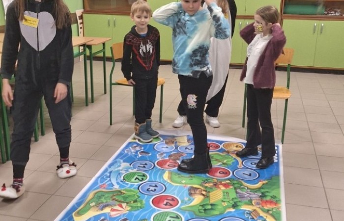 26 lutego w naszej szkole odbył się wyjątkowy DZIEŃ OTWARTY, podczas którego mieliśmy przyjemność gościć przedszkolaków, przyszłych uczniów oraz ich rodziców. Była to doskonała okazja, aby poczuć atmosferę naszej szkoły, poznać jej ofertę edukacyjną i odkryć to, co czyni ją miejscem pełnym pasji, wiedzy i radości.
Zwiedzanie naszej placówki obejmowało sale przedmiotowe, bibliotekę, stołówkę, świetlicę oraz małą salę gimnastyczną, gdzie można było na własnej skórze poczuć rytm codziennego życia naszej szkolnej społeczności.
Na odwiedzających czekało mnóstwo niespodzianek! Zachętą do działania były pieczątki, które najmłodsi otrzymywali w nagrodę za wykonanie przeróżnych zadań. W sali gimnastycznej na uczestników czekały ekscytujące konkurencje sprawnościowe, a w pracowni kulinarnej – pachnące i chrupiące gofry własnej roboty. Młodzi odkrywcy mieli okazję badać świat przez mikroskop, eksperymentować z interaktywnymi robotami Photon oraz brać udział w zajęciach z robotyki. Z kolei miłośnicy sztuki mogli tworzyć piękne dzieła na warsztatach plastycznych i origami, a najmłodsi cieszyli się malowaniem twarzy.
Nie zabrakło także wyzwań dla bystrego umysłu! Gry i zabawy językowe, rebusy oraz polonistyczne łamigłówki rozbudzały wyobraźnię i rozwijały umiejętności językowe. Wesoła „Gimnastyka buzi i języka” sprawiła, że ćwiczenie dykcji stało się czystą przyjemnością. Ogromnym zainteresowaniem cieszyły się również gry planszowe, które dostarczyły mnóstwa radości i emocjonującej rywalizacji. Dodatkowo, zabawy z chustą Klanza okazały się świetnym sposobem na integrację i wspólną zabawę pełną śmiechu.
Aktywne zwiedzanie stało się więc okazją do rozwijania ciekawości świata, nabywania nowych umiejętności, pobudzania w najmłodszych kreatywności oraz odczuwania satysfakcji z osiągniętego sukcesu.