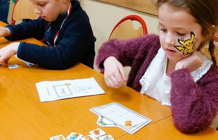 26 lutego w naszej szkole odbył się wyjątkowy DZIEŃ OTWARTY, podczas którego mieliśmy przyjemność gościć przedszkolaków, przyszłych uczniów oraz ich rodziców. Była to doskonała okazja, aby poczuć atmosferę naszej szkoły, poznać jej ofertę edukacyjną i odkryć to, co czyni ją miejscem pełnym pasji, wiedzy i radości.
Zwiedzanie naszej placówki obejmowało sale przedmiotowe, bibliotekę, stołówkę, świetlicę oraz małą salę gimnastyczną, gdzie można było na własnej skórze poczuć rytm codziennego życia naszej szkolnej społeczności.
Na odwiedzających czekało mnóstwo niespodzianek! Zachętą do działania były pieczątki, które najmłodsi otrzymywali w nagrodę za wykonanie przeróżnych zadań. W sali gimnastycznej na uczestników czekały ekscytujące konkurencje sprawnościowe, a w pracowni kulinarnej – pachnące i chrupiące gofry własnej roboty. Młodzi odkrywcy mieli okazję badać świat przez mikroskop, eksperymentować z interaktywnymi robotami Photon oraz brać udział w zajęciach z robotyki. Z kolei miłośnicy sztuki mogli tworzyć piękne dzieła na warsztatach plastycznych i origami, a najmłodsi cieszyli się malowaniem twarzy.
Nie zabrakło także wyzwań dla bystrego umysłu! Gry i zabawy językowe, rebusy oraz polonistyczne łamigłówki rozbudzały wyobraźnię i rozwijały umiejętności językowe. Wesoła „Gimnastyka buzi i języka” sprawiła, że ćwiczenie dykcji stało się czystą przyjemnością. Ogromnym zainteresowaniem cieszyły się również gry planszowe, które dostarczyły mnóstwa radości i emocjonującej rywalizacji. Dodatkowo, zabawy z chustą Klanza okazały się świetnym sposobem na integrację i wspólną zabawę pełną śmiechu.
Aktywne zwiedzanie stało się więc okazją do rozwijania ciekawości świata, nabywania nowych umiejętności, pobudzania w najmłodszych kreatywności oraz odczuwania satysfakcji z osiągniętego sukcesu.