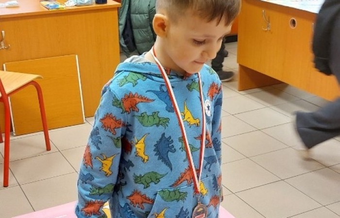 26 lutego w naszej szkole odbył się wyjątkowy DZIEŃ OTWARTY, podczas którego mieliśmy przyjemność gościć przedszkolaków, przyszłych uczniów oraz ich rodziców. Była to doskonała okazja, aby poczuć atmosferę naszej szkoły, poznać jej ofertę edukacyjną i odkryć to, co czyni ją miejscem pełnym pasji, wiedzy i radości.
Zwiedzanie naszej placówki obejmowało sale przedmiotowe, bibliotekę, stołówkę, świetlicę oraz małą salę gimnastyczną, gdzie można było na własnej skórze poczuć rytm codziennego życia naszej szkolnej społeczności.
Na odwiedzających czekało mnóstwo niespodzianek! Zachętą do działania były pieczątki, które najmłodsi otrzymywali w nagrodę za wykonanie przeróżnych zadań. W sali gimnastycznej na uczestników czekały ekscytujące konkurencje sprawnościowe, a w pracowni kulinarnej – pachnące i chrupiące gofry własnej roboty. Młodzi odkrywcy mieli okazję badać świat przez mikroskop, eksperymentować z interaktywnymi robotami Photon oraz brać udział w zajęciach z robotyki. Z kolei miłośnicy sztuki mogli tworzyć piękne dzieła na warsztatach plastycznych i origami, a najmłodsi cieszyli się malowaniem twarzy.
Nie zabrakło także wyzwań dla bystrego umysłu! Gry i zabawy językowe, rebusy oraz polonistyczne łamigłówki rozbudzały wyobraźnię i rozwijały umiejętności językowe. Wesoła „Gimnastyka buzi i języka” sprawiła, że ćwiczenie dykcji stało się czystą przyjemnością. Ogromnym zainteresowaniem cieszyły się również gry planszowe, które dostarczyły mnóstwa radości i emocjonującej rywalizacji. Dodatkowo, zabawy z chustą Klanza okazały się świetnym sposobem na integrację i wspólną zabawę pełną śmiechu.
Aktywne zwiedzanie stało się więc okazją do rozwijania ciekawości świata, nabywania nowych umiejętności, pobudzania w najmłodszych kreatywności oraz odczuwania satysfakcji z osiągniętego sukcesu.