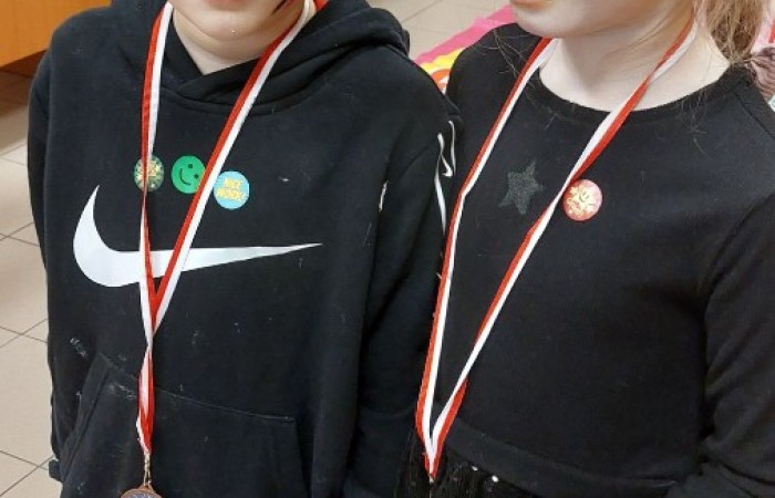 26 lutego w naszej szkole odbył się wyjątkowy DZIEŃ OTWARTY, podczas którego mieliśmy przyjemność gościć przedszkolaków, przyszłych uczniów oraz ich rodziców. Była to doskonała okazja, aby poczuć atmosferę naszej szkoły, poznać jej ofertę edukacyjną i odkryć to, co czyni ją miejscem pełnym pasji, wiedzy i radości.
Zwiedzanie naszej placówki obejmowało sale przedmiotowe, bibliotekę, stołówkę, świetlicę oraz małą salę gimnastyczną, gdzie można było na własnej skórze poczuć rytm codziennego życia naszej szkolnej społeczności.
Na odwiedzających czekało mnóstwo niespodzianek! Zachętą do działania były pieczątki, które najmłodsi otrzymywali w nagrodę za wykonanie przeróżnych zadań. W sali gimnastycznej na uczestników czekały ekscytujące konkurencje sprawnościowe, a w pracowni kulinarnej – pachnące i chrupiące gofry własnej roboty. Młodzi odkrywcy mieli okazję badać świat przez mikroskop, eksperymentować z interaktywnymi robotami Photon oraz brać udział w zajęciach z robotyki. Z kolei miłośnicy sztuki mogli tworzyć piękne dzieła na warsztatach plastycznych i origami, a najmłodsi cieszyli się malowaniem twarzy.
Nie zabrakło także wyzwań dla bystrego umysłu! Gry i zabawy językowe, rebusy oraz polonistyczne łamigłówki rozbudzały wyobraźnię i rozwijały umiejętności językowe. Wesoła „Gimnastyka buzi i języka” sprawiła, że ćwiczenie dykcji stało się czystą przyjemnością. Ogromnym zainteresowaniem cieszyły się również gry planszowe, które dostarczyły mnóstwa radości i emocjonującej rywalizacji. Dodatkowo, zabawy z chustą Klanza okazały się świetnym sposobem na integrację i wspólną zabawę pełną śmiechu.
Aktywne zwiedzanie stało się więc okazją do rozwijania ciekawości świata, nabywania nowych umiejętności, pobudzania w najmłodszych kreatywności oraz odczuwania satysfakcji z osiągniętego sukcesu.