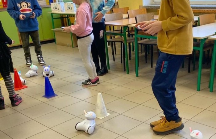 26 lutego w naszej szkole odbył się wyjątkowy DZIEŃ OTWARTY, podczas którego mieliśmy przyjemność gościć przedszkolaków, przyszłych uczniów oraz ich rodziców. Była to doskonała okazja, aby poczuć atmosferę naszej szkoły, poznać jej ofertę edukacyjną i odkryć to, co czyni ją miejscem pełnym pasji, wiedzy i radości.
Zwiedzanie naszej placówki obejmowało sale przedmiotowe, bibliotekę, stołówkę, świetlicę oraz małą salę gimnastyczną, gdzie można było na własnej skórze poczuć rytm codziennego życia naszej szkolnej społeczności.
Na odwiedzających czekało mnóstwo niespodzianek! Zachętą do działania były pieczątki, które najmłodsi otrzymywali w nagrodę za wykonanie przeróżnych zadań. W sali gimnastycznej na uczestników czekały ekscytujące konkurencje sprawnościowe, a w pracowni kulinarnej – pachnące i chrupiące gofry własnej roboty. Młodzi odkrywcy mieli okazję badać świat przez mikroskop, eksperymentować z interaktywnymi robotami Photon oraz brać udział w zajęciach z robotyki. Z kolei miłośnicy sztuki mogli tworzyć piękne dzieła na warsztatach plastycznych i origami, a najmłodsi cieszyli się malowaniem twarzy.
Nie zabrakło także wyzwań dla bystrego umysłu! Gry i zabawy językowe, rebusy oraz polonistyczne łamigłówki rozbudzały wyobraźnię i rozwijały umiejętności językowe. Wesoła „Gimnastyka buzi i języka” sprawiła, że ćwiczenie dykcji stało się czystą przyjemnością. Ogromnym zainteresowaniem cieszyły się również gry planszowe, które dostarczyły mnóstwa radości i emocjonującej rywalizacji. Dodatkowo, zabawy z chustą Klanza okazały się świetnym sposobem na integrację i wspólną zabawę pełną śmiechu.
Aktywne zwiedzanie stało się więc okazją do rozwijania ciekawości świata, nabywania nowych umiejętności, pobudzania w najmłodszych kreatywności oraz odczuwania satysfakcji z osiągniętego sukcesu.