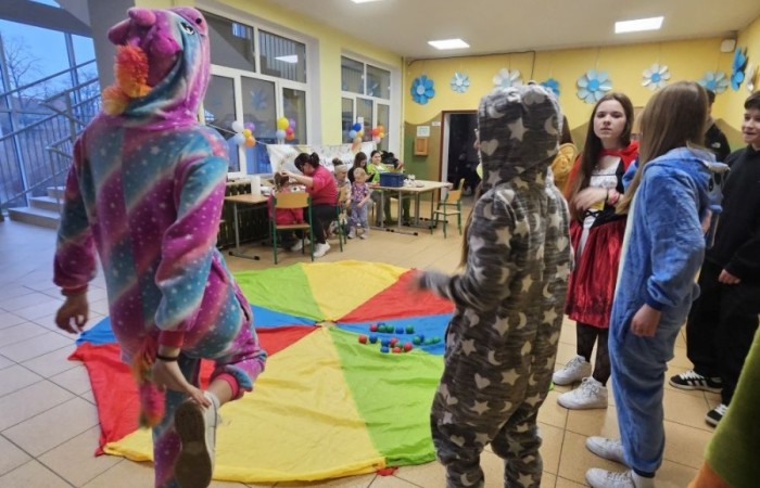 26 lutego w naszej szkole odbył się wyjątkowy DZIEŃ OTWARTY, podczas którego mieliśmy przyjemność gościć przedszkolaków, przyszłych uczniów oraz ich rodziców. Była to doskonała okazja, aby poczuć atmosferę naszej szkoły, poznać jej ofertę edukacyjną i odkryć to, co czyni ją miejscem pełnym pasji, wiedzy i radości.
Zwiedzanie naszej placówki obejmowało sale przedmiotowe, bibliotekę, stołówkę, świetlicę oraz małą salę gimnastyczną, gdzie można było na własnej skórze poczuć rytm codziennego życia naszej szkolnej społeczności.
Na odwiedzających czekało mnóstwo niespodzianek! Zachętą do działania były pieczątki, które najmłodsi otrzymywali w nagrodę za wykonanie przeróżnych zadań. W sali gimnastycznej na uczestników czekały ekscytujące konkurencje sprawnościowe, a w pracowni kulinarnej – pachnące i chrupiące gofry własnej roboty. Młodzi odkrywcy mieli okazję badać świat przez mikroskop, eksperymentować z interaktywnymi robotami Photon oraz brać udział w zajęciach z robotyki. Z kolei miłośnicy sztuki mogli tworzyć piękne dzieła na warsztatach plastycznych i origami, a najmłodsi cieszyli się malowaniem twarzy.
Nie zabrakło także wyzwań dla bystrego umysłu! Gry i zabawy językowe, rebusy oraz polonistyczne łamigłówki rozbudzały wyobraźnię i rozwijały umiejętności językowe. Wesoła „Gimnastyka buzi i języka” sprawiła, że ćwiczenie dykcji stało się czystą przyjemnością. Ogromnym zainteresowaniem cieszyły się również gry planszowe, które dostarczyły mnóstwa radości i emocjonującej rywalizacji. Dodatkowo, zabawy z chustą Klanza okazały się świetnym sposobem na integrację i wspólną zabawę pełną śmiechu.
Aktywne zwiedzanie stało się więc okazją do rozwijania ciekawości świata, nabywania nowych umiejętności, pobudzania w najmłodszych kreatywności oraz odczuwania satysfakcji z osiągniętego sukcesu.