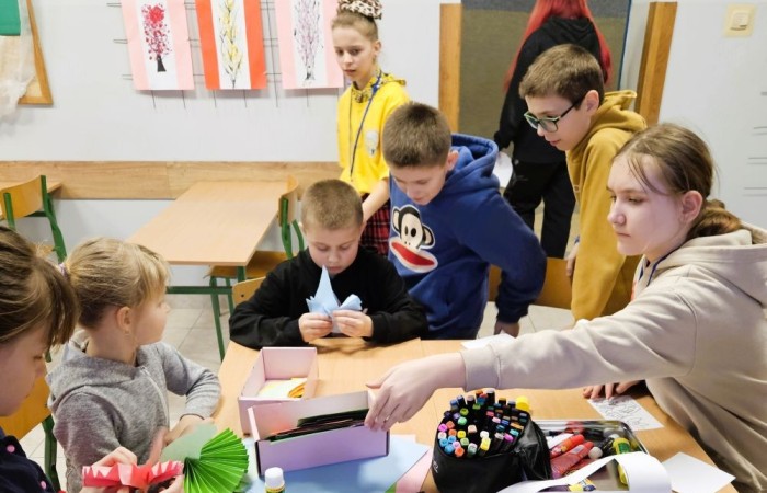 26 lutego w naszej szkole odbył się wyjątkowy DZIEŃ OTWARTY, podczas którego mieliśmy przyjemność gościć przedszkolaków, przyszłych uczniów oraz ich rodziców. Była to doskonała okazja, aby poczuć atmosferę naszej szkoły, poznać jej ofertę edukacyjną i odkryć to, co czyni ją miejscem pełnym pasji, wiedzy i radości.
Zwiedzanie naszej placówki obejmowało sale przedmiotowe, bibliotekę, stołówkę, świetlicę oraz małą salę gimnastyczną, gdzie można było na własnej skórze poczuć rytm codziennego życia naszej szkolnej społeczności.
Na odwiedzających czekało mnóstwo niespodzianek! Zachętą do działania były pieczątki, które najmłodsi otrzymywali w nagrodę za wykonanie przeróżnych zadań. W sali gimnastycznej na uczestników czekały ekscytujące konkurencje sprawnościowe, a w pracowni kulinarnej – pachnące i chrupiące gofry własnej roboty. Młodzi odkrywcy mieli okazję badać świat przez mikroskop, eksperymentować z interaktywnymi robotami Photon oraz brać udział w zajęciach z robotyki. Z kolei miłośnicy sztuki mogli tworzyć piękne dzieła na warsztatach plastycznych i origami, a najmłodsi cieszyli się malowaniem twarzy.
Nie zabrakło także wyzwań dla bystrego umysłu! Gry i zabawy językowe, rebusy oraz polonistyczne łamigłówki rozbudzały wyobraźnię i rozwijały umiejętności językowe. Wesoła „Gimnastyka buzi i języka” sprawiła, że ćwiczenie dykcji stało się czystą przyjemnością. Ogromnym zainteresowaniem cieszyły się również gry planszowe, które dostarczyły mnóstwa radości i emocjonującej rywalizacji. Dodatkowo, zabawy z chustą Klanza okazały się świetnym sposobem na integrację i wspólną zabawę pełną śmiechu.
Aktywne zwiedzanie stało się więc okazją do rozwijania ciekawości świata, nabywania nowych umiejętności, pobudzania w najmłodszych kreatywności oraz odczuwania satysfakcji z osiągniętego sukcesu.