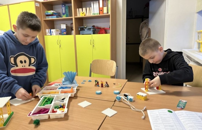 26 lutego w naszej szkole odbył się wyjątkowy DZIEŃ OTWARTY, podczas którego mieliśmy przyjemność gościć przedszkolaków, przyszłych uczniów oraz ich rodziców. Była to doskonała okazja, aby poczuć atmosferę naszej szkoły, poznać jej ofertę edukacyjną i odkryć to, co czyni ją miejscem pełnym pasji, wiedzy i radości.
Zwiedzanie naszej placówki obejmowało sale przedmiotowe, bibliotekę, stołówkę, świetlicę oraz małą salę gimnastyczną, gdzie można było na własnej skórze poczuć rytm codziennego życia naszej szkolnej społeczności.
Na odwiedzających czekało mnóstwo niespodzianek! Zachętą do działania były pieczątki, które najmłodsi otrzymywali w nagrodę za wykonanie przeróżnych zadań. W sali gimnastycznej na uczestników czekały ekscytujące konkurencje sprawnościowe, a w pracowni kulinarnej – pachnące i chrupiące gofry własnej roboty. Młodzi odkrywcy mieli okazję badać świat przez mikroskop, eksperymentować z interaktywnymi robotami Photon oraz brać udział w zajęciach z robotyki. Z kolei miłośnicy sztuki mogli tworzyć piękne dzieła na warsztatach plastycznych i origami, a najmłodsi cieszyli się malowaniem twarzy.
Nie zabrakło także wyzwań dla bystrego umysłu! Gry i zabawy językowe, rebusy oraz polonistyczne łamigłówki rozbudzały wyobraźnię i rozwijały umiejętności językowe. Wesoła „Gimnastyka buzi i języka” sprawiła, że ćwiczenie dykcji stało się czystą przyjemnością. Ogromnym zainteresowaniem cieszyły się również gry planszowe, które dostarczyły mnóstwa radości i emocjonującej rywalizacji. Dodatkowo, zabawy z chustą Klanza okazały się świetnym sposobem na integrację i wspólną zabawę pełną śmiechu.
Aktywne zwiedzanie stało się więc okazją do rozwijania ciekawości świata, nabywania nowych umiejętności, pobudzania w najmłodszych kreatywności oraz odczuwania satysfakcji z osiągniętego sukcesu.