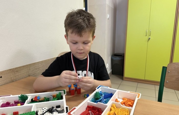 26 lutego w naszej szkole odbył się wyjątkowy DZIEŃ OTWARTY, podczas którego mieliśmy przyjemność gościć przedszkolaków, przyszłych uczniów oraz ich rodziców. Była to doskonała okazja, aby poczuć atmosferę naszej szkoły, poznać jej ofertę edukacyjną i odkryć to, co czyni ją miejscem pełnym pasji, wiedzy i radości.
Zwiedzanie naszej placówki obejmowało sale przedmiotowe, bibliotekę, stołówkę, świetlicę oraz małą salę gimnastyczną, gdzie można było na własnej skórze poczuć rytm codziennego życia naszej szkolnej społeczności.
Na odwiedzających czekało mnóstwo niespodzianek! Zachętą do działania były pieczątki, które najmłodsi otrzymywali w nagrodę za wykonanie przeróżnych zadań. W sali gimnastycznej na uczestników czekały ekscytujące konkurencje sprawnościowe, a w pracowni kulinarnej – pachnące i chrupiące gofry własnej roboty. Młodzi odkrywcy mieli okazję badać świat przez mikroskop, eksperymentować z interaktywnymi robotami Photon oraz brać udział w zajęciach z robotyki. Z kolei miłośnicy sztuki mogli tworzyć piękne dzieła na warsztatach plastycznych i origami, a najmłodsi cieszyli się malowaniem twarzy.
Nie zabrakło także wyzwań dla bystrego umysłu! Gry i zabawy językowe, rebusy oraz polonistyczne łamigłówki rozbudzały wyobraźnię i rozwijały umiejętności językowe. Wesoła „Gimnastyka buzi i języka” sprawiła, że ćwiczenie dykcji stało się czystą przyjemnością. Ogromnym zainteresowaniem cieszyły się również gry planszowe, które dostarczyły mnóstwa radości i emocjonującej rywalizacji. Dodatkowo, zabawy z chustą Klanza okazały się świetnym sposobem na integrację i wspólną zabawę pełną śmiechu.
Aktywne zwiedzanie stało się więc okazją do rozwijania ciekawości świata, nabywania nowych umiejętności, pobudzania w najmłodszych kreatywności oraz odczuwania satysfakcji z osiągniętego sukcesu.