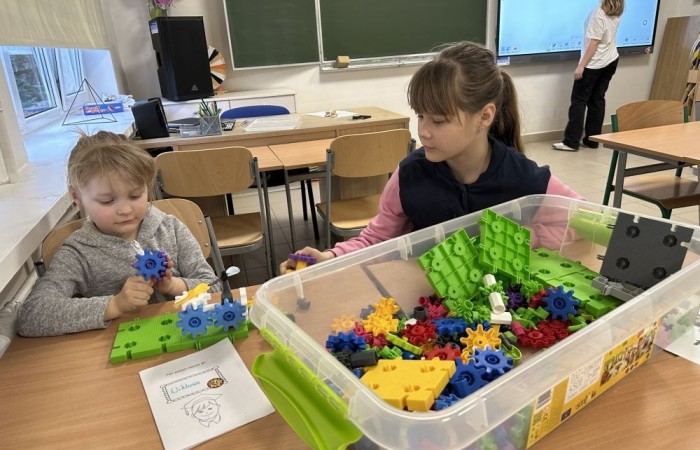 26 lutego w naszej szkole odbył się wyjątkowy DZIEŃ OTWARTY, podczas którego mieliśmy przyjemność gościć przedszkolaków, przyszłych uczniów oraz ich rodziców. Była to doskonała okazja, aby poczuć atmosferę naszej szkoły, poznać jej ofertę edukacyjną i odkryć to, co czyni ją miejscem pełnym pasji, wiedzy i radości.
Zwiedzanie naszej placówki obejmowało sale przedmiotowe, bibliotekę, stołówkę, świetlicę oraz małą salę gimnastyczną, gdzie można było na własnej skórze poczuć rytm codziennego życia naszej szkolnej społeczności.
Na odwiedzających czekało mnóstwo niespodzianek! Zachętą do działania były pieczątki, które najmłodsi otrzymywali w nagrodę za wykonanie przeróżnych zadań. W sali gimnastycznej na uczestników czekały ekscytujące konkurencje sprawnościowe, a w pracowni kulinarnej – pachnące i chrupiące gofry własnej roboty. Młodzi odkrywcy mieli okazję badać świat przez mikroskop, eksperymentować z interaktywnymi robotami Photon oraz brać udział w zajęciach z robotyki. Z kolei miłośnicy sztuki mogli tworzyć piękne dzieła na warsztatach plastycznych i origami, a najmłodsi cieszyli się malowaniem twarzy.
Nie zabrakło także wyzwań dla bystrego umysłu! Gry i zabawy językowe, rebusy oraz polonistyczne łamigłówki rozbudzały wyobraźnię i rozwijały umiejętności językowe. Wesoła „Gimnastyka buzi i języka” sprawiła, że ćwiczenie dykcji stało się czystą przyjemnością. Ogromnym zainteresowaniem cieszyły się również gry planszowe, które dostarczyły mnóstwa radości i emocjonującej rywalizacji. Dodatkowo, zabawy z chustą Klanza okazały się świetnym sposobem na integrację i wspólną zabawę pełną śmiechu.
Aktywne zwiedzanie stało się więc okazją do rozwijania ciekawości świata, nabywania nowych umiejętności, pobudzania w najmłodszych kreatywności oraz odczuwania satysfakcji z osiągniętego sukcesu.