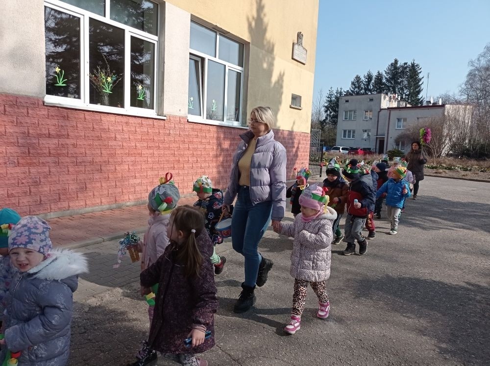 W piątek 21 marca wszystkie dzieci z naszego przedszkola świętowały nadejście wiosny. Dla każdego przedszkolaka jest to bardzo wyczekiwane wydarzenie. Dzień rozpoczęliśmy od rozmów o nowej porze roku oraz od wesołych zabaw przy muzyce. Uśmiechnięci wyruszyliśmy na spacer w okolicy naszego przedszkola, gdzie pożegnaliśmy zimę wraz z Marzanną. Dodatkowo dzieci próbowały odstraszyć zimę, śpiewając głośno piosenki i skandując hasła o wiośnie. I tak kolorowy, ale już wiosenny, uśmiechnięty pochód mógł wrócić do przedszkola. Cieszymy się, że w taki sposób mogliśmy w pełni przywitać wiosnę, która obdarowała nas pięknym słoneczkiem. Mamy nadzieję, że dzięki zaangażowaniu naszych przedszkolaków wiosna zawita do nas na dobre, a wraz z nią ciepłe dni, z których będziemy korzystać podczas zabaw na świeżym powietrzu.