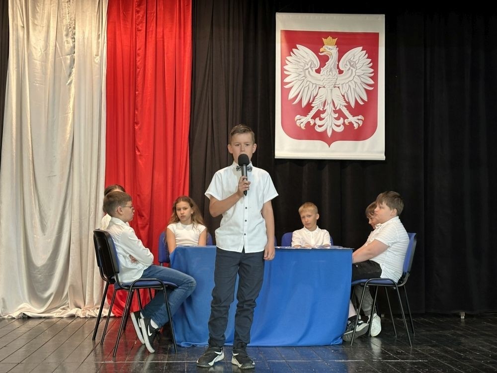 W przeddzień rocznicy uchwalenia Konstytucji 3 Maja w naszej szkole z tej okazji odbył się akademia przygotowana przez uczniów kl. IV a i IV b przy współudziale zespołu wokalnego.
Jego celem było budzenie wrażliwości uczniów na święta narodowe oraz kształtowanie postaw patriotycznych.
Akademia rozpoczęła się uroczystym odśpiewaniem hymnu państwowego. Następnie uczniowie klas czwartych przybliżyli wydarzenia tamtych dni. Zwrócono uwagę na poszanowanie barw narodowych przypominając, iż 2 maja obchodzimy Święto Flagi.
Korzystając z okazji,  pani dyrektor Agnieszka Cieklińska pogratulowała  Marcelowi Chełstowskiemu – Lanzer, uczniowi kl. VII b,  uzyskania  tytułu laureata w Konkursie z  Języka Niemieckiego organizowanego  przez Warmińsko – Mazurskiego Kuratora Oświaty w Olsztynie i wręczyła pamiątkowy dyplom.
Pani dyrektor wręczyła również dyplom pani Annie Cieśli, nauczycielce języka niemieckiego, dziękując za przygotowanie ucznia do konkursu.
Na zakończenie akademii pani Agnieszka Cieklińska życzyła całej społeczności szkolnej radosnego świętowana majowych dni.
