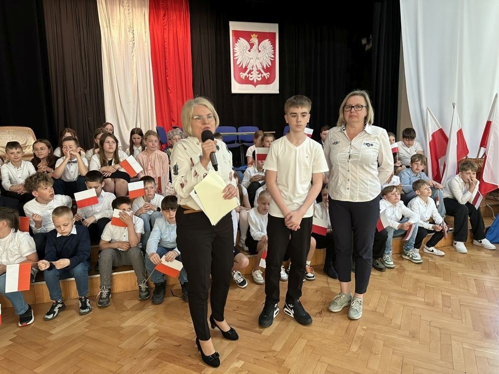 W przeddzień rocznicy uchwalenia Konstytucji 3 Maja w naszej szkole z tej okazji odbył się akademia przygotowana przez uczniów kl. IV a i IV b przy współudziale zespołu wokalnego.
Jego celem było budzenie wrażliwości uczniów na święta narodowe oraz kształtowanie postaw patriotycznych.
Akademia rozpoczęła się uroczystym odśpiewaniem hymnu państwowego. Następnie uczniowie klas czwartych przybliżyli wydarzenia tamtych dni. Zwrócono uwagę na poszanowanie barw narodowych przypominając, iż 2 maja obchodzimy Święto Flagi.
Korzystając z okazji,  pani dyrektor Agnieszka Cieklińska pogratulowała  Marcelowi Chełstowskiemu – Lanzer, uczniowi kl. VII b,  uzyskania  tytułu laureata w Konkursie z  Języka Niemieckiego organizowanego  przez Warmińsko – Mazurskiego Kuratora Oświaty w Olsztynie i wręczyła pamiątkowy dyplom.
Pani dyrektor wręczyła również dyplom pani Annie Cieśli, nauczycielce języka niemieckiego, dziękując za przygotowanie ucznia do konkursu.
Na zakończenie akademii pani Agnieszka Cieklińska życzyła całej społeczności szkolnej radosnego świętowana majowych dni.
