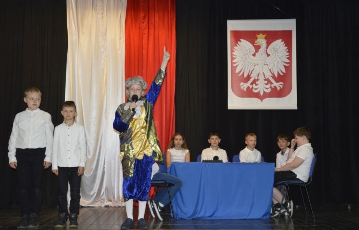 W przeddzień rocznicy uchwalenia Konstytucji 3 Maja w naszej szkole z tej okazji odbył się akademia przygotowana przez uczniów kl. IV a i IV b przy współudziale zespołu wokalnego.
Jego celem było budzenie wrażliwości uczniów na święta narodowe oraz kształtowanie postaw patriotycznych.
Akademia rozpoczęła się uroczystym odśpiewaniem hymnu państwowego. Następnie uczniowie klas czwartych przybliżyli wydarzenia tamtych dni. Zwrócono uwagę na poszanowanie barw narodowych przypominając, iż 2 maja obchodzimy Święto Flagi.
Korzystając z okazji,  pani dyrektor Agnieszka Cieklińska pogratulowała  Marcelowi Chełstowskiemu – Lanzer, uczniowi kl. VII b,  uzyskania  tytułu laureata w Konkursie z  Języka Niemieckiego organizowanego  przez Warmińsko – Mazurskiego Kuratora Oświaty w Olsztynie i wręczyła pamiątkowy dyplom.
Pani dyrektor wręczyła również dyplom pani Annie Cieśli, nauczycielce języka niemieckiego, dziękując za przygotowanie ucznia do konkursu.
Na zakończenie akademii pani Agnieszka Cieklińska życzyła całej społeczności szkolnej radosnego świętowana majowych dni.
