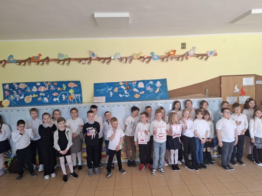 Dziś na szkolnym dziedzińcu zapanowała wyjątkowa, podniosła atmosfera. Uczniowie klas młodszych, ubrani w galowe stroje, z dumą stanęli do wspólnego odśpiewania hymnu Polski. W ich dłoniach powiewały biało-czerwone flagi, a serca wypełniała duma i szacunek dla Ojczyzny.
W ten sposób rozpoczęliśmy szkolne obchody zbliżających się świąt majowych – Święta Pracy (1 maja), Dnia Flagi Rzeczypospolitej Polskiej (2 maja) oraz Święta Konstytucji 3 Maja. To dla nas ważna lekcja historii, patriotyzmu i wspólnoty.

