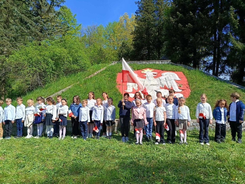 Dziś na szkolnym dziedzińcu zapanowała wyjątkowa, podniosła atmosfera. Uczniowie klas młodszych, ubrani w galowe stroje, z dumą stanęli do wspólnego odśpiewania hymnu Polski. W ich dłoniach powiewały biało-czerwone flagi, a serca wypełniała duma i szacunek dla Ojczyzny.
W ten sposób rozpoczęliśmy szkolne obchody zbliżających się świąt majowych – Święta Pracy (1 maja), Dnia Flagi Rzeczypospolitej Polskiej (2 maja) oraz Święta Konstytucji 3 Maja. To dla nas ważna lekcja historii, patriotyzmu i wspólnoty.


