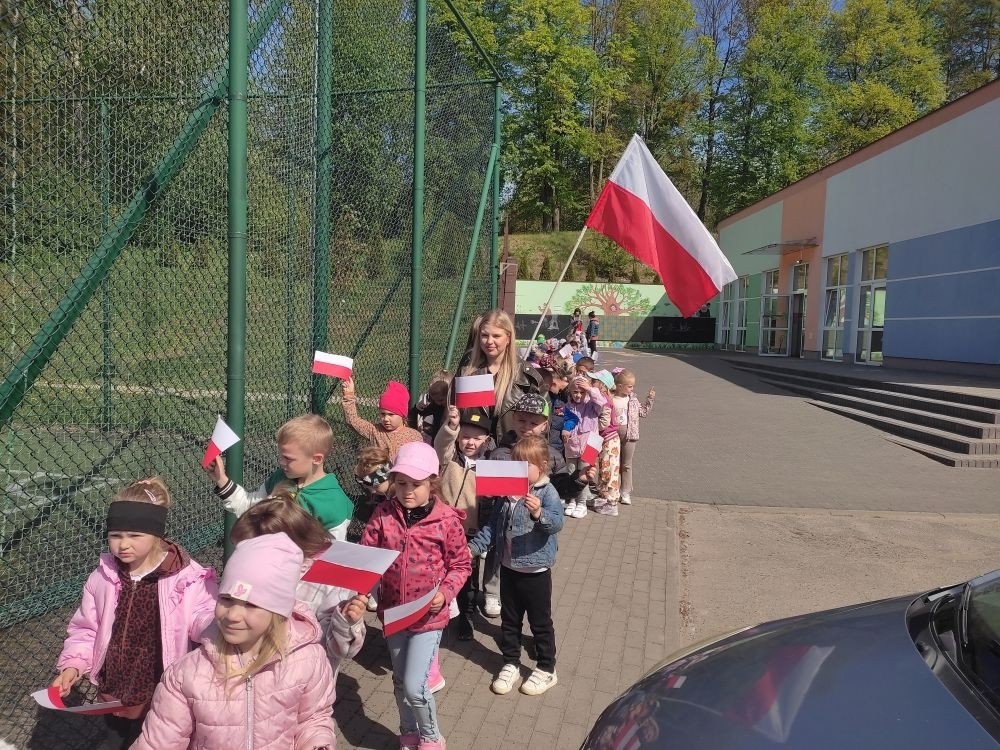 W środowe przedpołudnie, z okazji nadchodzącego Święta Flagi Rzeczypospolitej Polskiej oraz Święta Konstytucji 3 Maja, dzieci z oddziału przedszkolnego wzięły udział w wyjątkowym wydarzeniu – marszu majowym z biało-czerwonymi flagami. Dzieci przed przemarszem odśpiewały hymn narodowy „Mazurek Dąbrowskiego” i z uśmiechami na twarzach i z dumą dzierżąc flagi, przemaszerowały w najbliższej okolicy szkoły przypominając wszystkim o znaczeniu tych ważnych świąt. Na zakończenie zrobiliśmy sobie pamiątkowe zdjęcie na tle godła polskiego. 
Organizatorzy marszu – nauczyciele i dyrekcja szkoły – podkreślają, że takie działania są niezwykle ważne w procesie wychowania młodego pokolenia w duchu szacunku do ojczyzny i tradycji. Marsz majowy z flagami z pewnością na długo pozostanie w pamięci dzieci i stanie się coroczną tradycją. 
