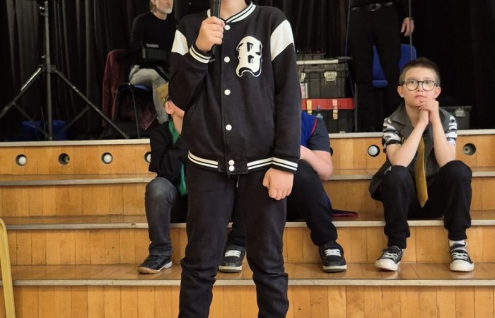 Dziś nasza szkoła na chwilę zamieniła się w scenę pełną świateł, dźwięków i... gwiazdorskiego blasku. Wszystko za sprawą koncertu, podczas którego rozstrzygnęliśmy szkolny konkurs wiedzy muzycznej. Temat przewodni? Życie muzycznej gwiazdy – a nasi uczniowie potraktowali to bardzo serio! Wybrani aktorzy-amatorzy (choć po dzisiejszym dniu to już prawie zawodowcy) wcielili się w rolę słynnego artysty i dali prawdziwy popis nie tylko wokalny. Były piosenki, taniec, emocje, dramat sceniczny i masa dobrej zabawy. Publiczność śpiewała i tańczyła razem z nimi, jak na prawdziwym koncercie. Gdyby ktoś zapytał, co dziś działo się w naszej szkole – odpowiedź jest prosta: muzyka, emocje i zabawa na całego.