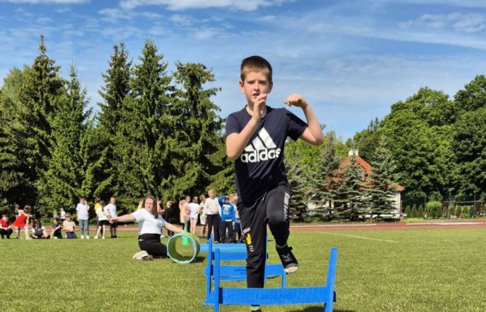 Tegoroczne obchody rozpoczęliśmy twórczo – od przygotowania plakatów „Mistrz zdrowia”. Po tej kreatywnej rozgrzewce przyszedł czas na sportowe emocje. Uroczyste otwarcie było tylko wstępem do licznych atrakcji, które czekały na dzieci na stadionie. Dzięki zaangażowaniu pana Piotra Borysewicza i sportowców z KS Polonia Pasłęk sekcji lekkoatletycznej, uczniowie mogli spróbować swoich sił w biegu przez płotki, rzucie piłeczką oraz torze przeszkód w stylu „Ninja Warrior”. Ogromną atrakcją była również wizyta strażaków z JRG 3 w Pasłęku, którzy zapewnili dzieciom wodno-pianową zabawę. Radość na twarzach uczestników mówiła sama za siebie. Na wszystkich zgłodniałych czekały pyszności, w tym słodka wata cukrowa, serwowana przez Panie z Koła Gospodyń Wiejskich w Borzynowie. Szczególne podziękowania kierujemy do niezastąpionych Rodziców – za wsparcie organizacyjne, opiekę podczas wydarzenia oraz przygotowanie dodatkowych atrakcji: plenerowego studia malowania twarzy i tatuaży. Na zakończenie nikt nie wyszedł z pustymi rękami – niezależnie od wyników konkursów każdy uczeń otrzymał drobny upominek i medal. To wyjątkowe święto pełne radości i zabawy już za nami, więc zaczynamy odliczanie do kolejnego Dnia Dziecka!