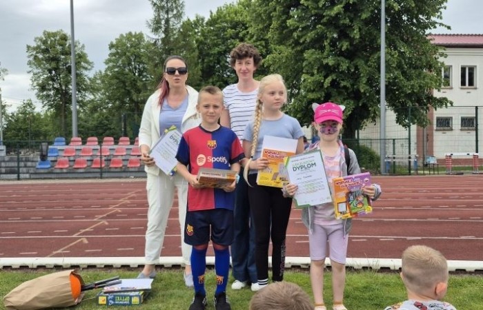 Tegoroczne obchody rozpoczęliśmy twórczo – od przygotowania plakatów „Mistrz zdrowia”. Po tej kreatywnej rozgrzewce przyszedł czas na sportowe emocje. Uroczyste otwarcie było tylko wstępem do licznych atrakcji, które czekały na dzieci na stadionie. Dzięki zaangażowaniu pana Piotra Borysewicza i sportowców z KS Polonia Pasłęk sekcji lekkoatletycznej, uczniowie mogli spróbować swoich sił w biegu przez płotki, rzucie piłeczką oraz torze przeszkód w stylu „Ninja Warrior”. Ogromną atrakcją była również wizyta strażaków z JRG 3 w Pasłęku, którzy zapewnili dzieciom wodno-pianową zabawę. Radość na twarzach uczestników mówiła sama za siebie. Na wszystkich zgłodniałych czekały pyszności, w tym słodka wata cukrowa, serwowana przez Panie z Koła Gospodyń Wiejskich w Borzynowie. Szczególne podziękowania kierujemy do niezastąpionych Rodziców – za wsparcie organizacyjne, opiekę podczas wydarzenia oraz przygotowanie dodatkowych atrakcji: plenerowego studia malowania twarzy i tatuaży. Na zakończenie nikt nie wyszedł z pustymi rękami – niezależnie od wyników konkursów każdy uczeń otrzymał drobny upominek i medal. To wyjątkowe święto pełne radości i zabawy już za nami, więc zaczynamy odliczanie do kolejnego Dnia Dziecka!