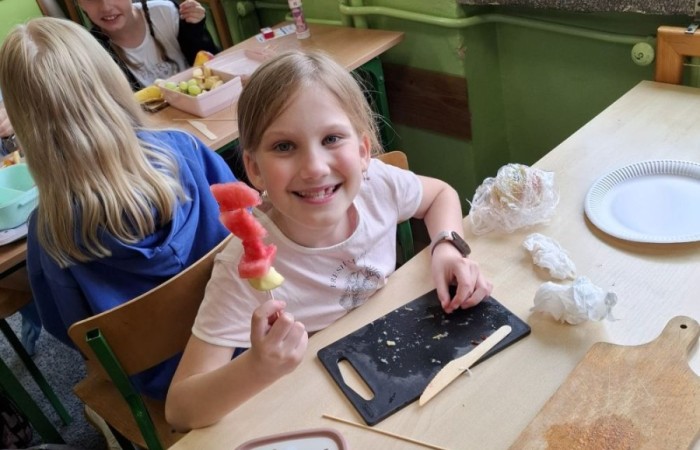 W klasie 2a zrobiło się kolorowo, zdrowo i pysznie. Uczniowie z ogromnym zaangażowaniem przygotowywali owocowe szaszłyki, które zachwycały nie tylko smakiem, ale też wyglądem. Na stołach królowały ulubione owoce dzieci: truskawki, winogrona, banany, kiwi, jabłka i wiele innych. Każdy samodzielnie kroił owoce i tworzył własne, kreatywne kompozycje. To była nie tylko smakowita zabawa, ale również świetna okazja do rozmów o zdrowym odżywianiu oraz nauki współpracy.