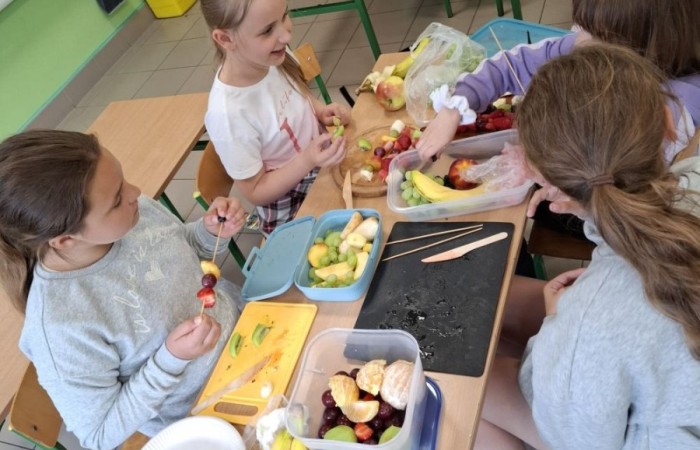 W klasie 2a zrobiło się kolorowo, zdrowo i pysznie. Uczniowie z ogromnym zaangażowaniem przygotowywali owocowe szaszłyki, które zachwycały nie tylko smakiem, ale też wyglądem. Na stołach królowały ulubione owoce dzieci: truskawki, winogrona, banany, kiwi, jabłka i wiele innych. Każdy samodzielnie kroił owoce i tworzył własne, kreatywne kompozycje. To była nie tylko smakowita zabawa, ale również świetna okazja do rozmów o zdrowym odżywianiu oraz nauki współpracy.