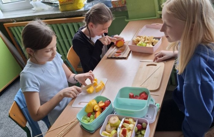 W klasie 2a zrobiło się kolorowo, zdrowo i pysznie. Uczniowie z ogromnym zaangażowaniem przygotowywali owocowe szaszłyki, które zachwycały nie tylko smakiem, ale też wyglądem. Na stołach królowały ulubione owoce dzieci: truskawki, winogrona, banany, kiwi, jabłka i wiele innych. Każdy samodzielnie kroił owoce i tworzył własne, kreatywne kompozycje. To była nie tylko smakowita zabawa, ale również świetna okazja do rozmów o zdrowym odżywianiu oraz nauki współpracy.