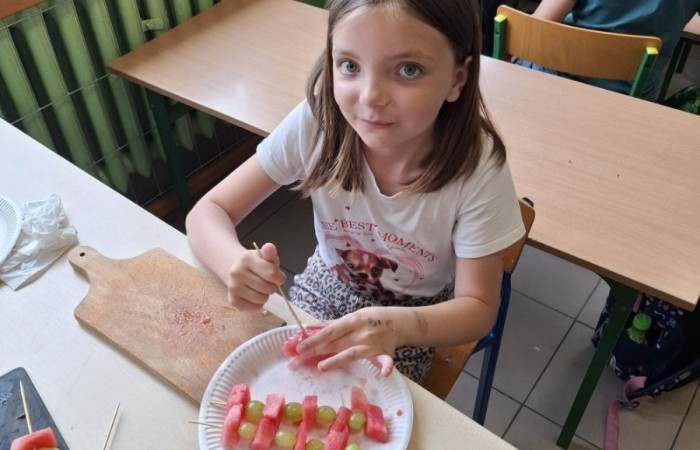 W klasie 2a zrobiło się kolorowo, zdrowo i pysznie. Uczniowie z ogromnym zaangażowaniem przygotowywali owocowe szaszłyki, które zachwycały nie tylko smakiem, ale też wyglądem. Na stołach królowały ulubione owoce dzieci: truskawki, winogrona, banany, kiwi, jabłka i wiele innych. Każdy samodzielnie kroił owoce i tworzył własne, kreatywne kompozycje. To była nie tylko smakowita zabawa, ale również świetna okazja do rozmów o zdrowym odżywianiu oraz nauki współpracy.
