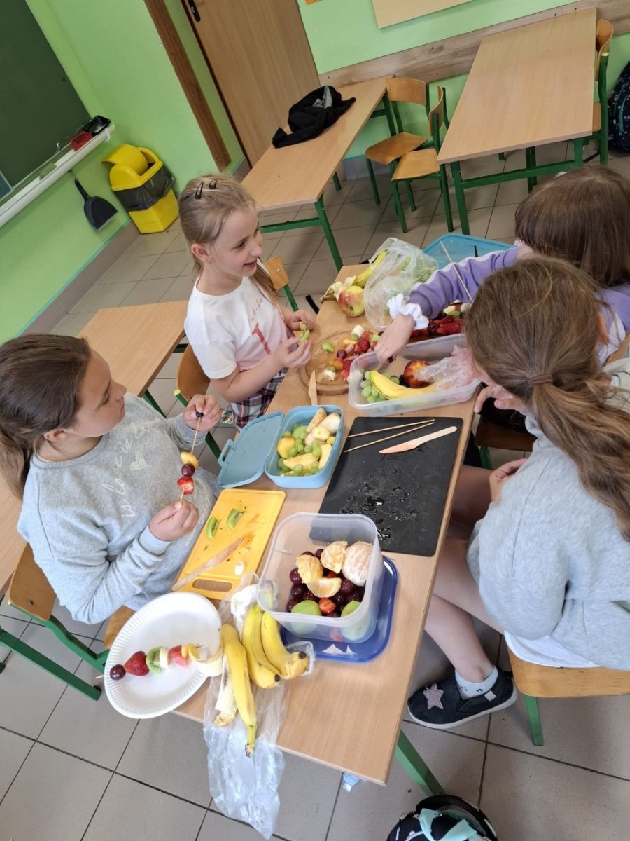 W klasie 2a zrobiło się kolorowo, zdrowo i pysznie. Uczniowie z ogromnym zaangażowaniem przygotowywali owocowe szaszłyki, które zachwycały nie tylko smakiem, ale też wyglądem. Na stołach królowały ulubione owoce dzieci: truskawki, winogrona, banany, kiwi, jabłka i wiele innych. Każdy samodzielnie kroił owoce i tworzył własne, kreatywne kompozycje. To była nie tylko smakowita zabawa, ale również świetna okazja do rozmów o zdrowym odżywianiu oraz nauki współpracy.