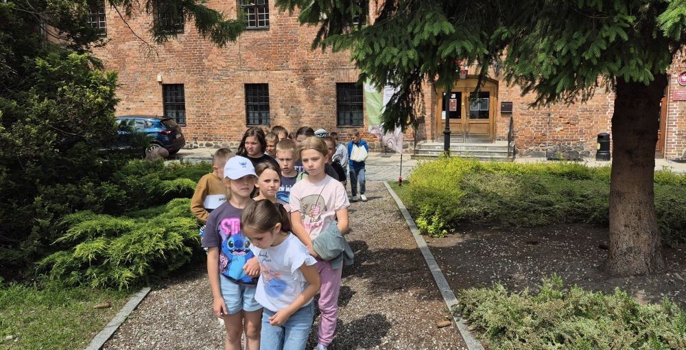 Uczniowie klasy 2B odwiedzili Bibliotekę Publiczną w Pasłęku, gdzie czekała na nich prawdziwa detektywistyczna przygoda z bohaterem znanej lektury – Detektywem Pozytywką.
Dzieci sprawdziły swoją znajomość książki, poznały ciekawostki o autorze – Grzegorzu Kasdepke, a także wzięły udział w quizach i zadaniach zespołowych. Przez chwilę mogły poczuć się jak prawdziwi detektywi – wykazując się nie tylko sprytem i spostrzegawczością, ale też świetną kondycją. Po dniu pełnym wrażeń przyszedł czas na słodki finał – wspólne wyjście na pyszne lody.
Kto wie, może wśród uczniów rosną przyszli następcy detektywa Pozytywki? Jedno jest pewne – pojawili się entuzjastyczni i zaangażowani miłośnicy książek.

