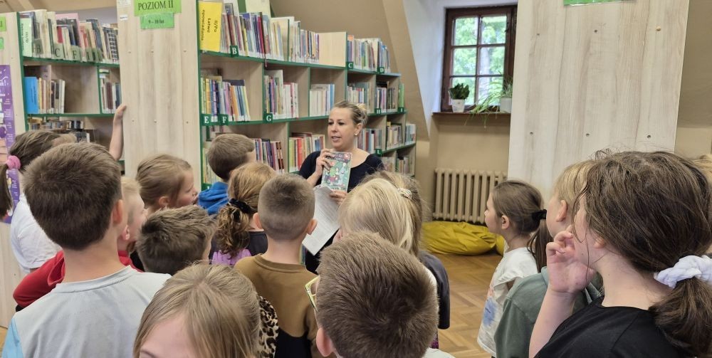Uczniowie klasy 2B odwiedzili Bibliotekę Publiczną w Pasłęku, gdzie czekała na nich prawdziwa detektywistyczna przygoda z bohaterem znanej lektury – Detektywem Pozytywką.
Dzieci sprawdziły swoją znajomość książki, poznały ciekawostki o autorze – Grzegorzu Kasdepke, a także wzięły udział w quizach i zadaniach zespołowych. Przez chwilę mogły poczuć się jak prawdziwi detektywi – wykazując się nie tylko sprytem i spostrzegawczością, ale też świetną kondycją. Po dniu pełnym wrażeń przyszedł czas na słodki finał – wspólne wyjście na pyszne lody.
Kto wie, może wśród uczniów rosną przyszli następcy detektywa Pozytywki? Jedno jest pewne – pojawili się entuzjastyczni i zaangażowani miłośnicy książek.
