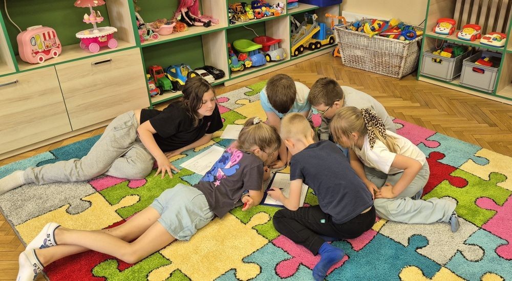 Uczniowie klasy 2B odwiedzili Bibliotekę Publiczną w Pasłęku, gdzie czekała na nich prawdziwa detektywistyczna przygoda z bohaterem znanej lektury – Detektywem Pozytywką.
Dzieci sprawdziły swoją znajomość książki, poznały ciekawostki o autorze – Grzegorzu Kasdepke, a także wzięły udział w quizach i zadaniach zespołowych. Przez chwilę mogły poczuć się jak prawdziwi detektywi – wykazując się nie tylko sprytem i spostrzegawczością, ale też świetną kondycją. Po dniu pełnym wrażeń przyszedł czas na słodki finał – wspólne wyjście na pyszne lody.
Kto wie, może wśród uczniów rosną przyszli następcy detektywa Pozytywki? Jedno jest pewne – pojawili się entuzjastyczni i zaangażowani miłośnicy książek.

