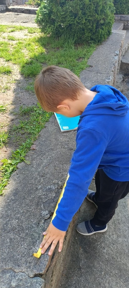 Klasa 1a ruszyła dziś z miarkami krawieckimi na szkolny plac, żeby sprawdzić, ile mierzy… brama, śmietnik i krawężnik. Dzięki praktycznym zajęciom dzieci nie tylko utrwaliły pojęcia związane z długością, ale też świetnie się bawiły mierząc wszystko, co tylko dało się zmierzyć. Takie lekcje to prawdziwa frajda – nauka przez działanie i odkrywanie świata wokół nas.