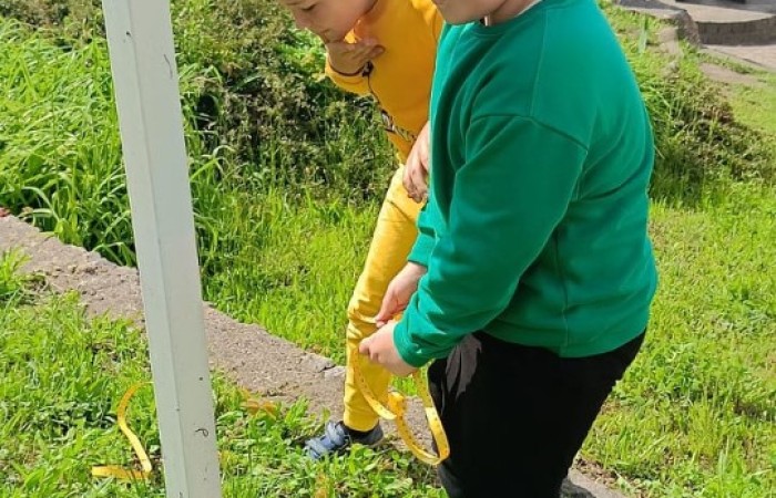 Klasa 1a ruszyła dziś z miarkami krawieckimi na szkolny plac, żeby sprawdzić, ile mierzy… brama, śmietnik i krawężnik. Dzięki praktycznym zajęciom dzieci nie tylko utrwaliły pojęcia związane z długością, ale też świetnie się bawiły mierząc wszystko, co tylko dało się zmierzyć. Takie lekcje to prawdziwa frajda – nauka przez działanie i odkrywanie świata wokół nas.