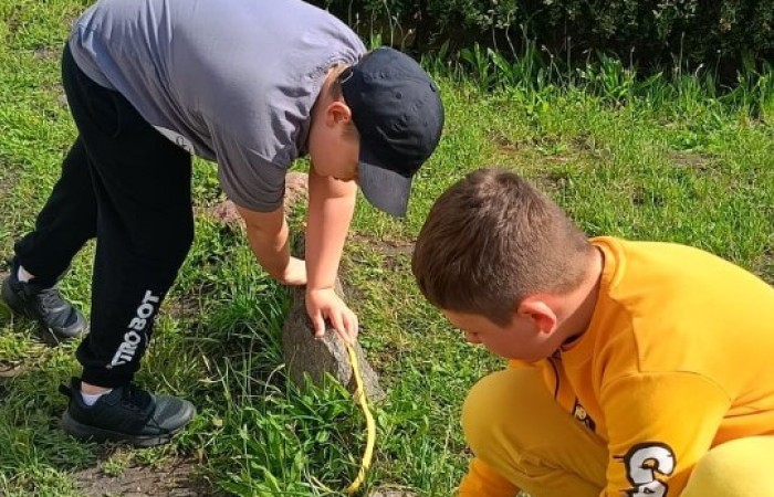 Klasa 1a ruszyła dziś z miarkami krawieckimi na szkolny plac, żeby sprawdzić, ile mierzy… brama, śmietnik i krawężnik. Dzięki praktycznym zajęciom dzieci nie tylko utrwaliły pojęcia związane z długością, ale też świetnie się bawiły mierząc wszystko, co tylko dało się zmierzyć. Takie lekcje to prawdziwa frajda – nauka przez działanie i odkrywanie świata wokół nas.