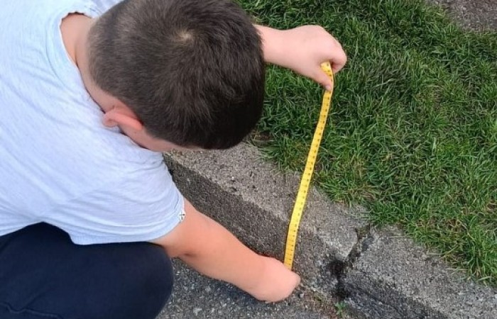 Klasa 1a ruszyła dziś z miarkami krawieckimi na szkolny plac, żeby sprawdzić, ile mierzy… brama, śmietnik i krawężnik. Dzięki praktycznym zajęciom dzieci nie tylko utrwaliły pojęcia związane z długością, ale też świetnie się bawiły mierząc wszystko, co tylko dało się zmierzyć. Takie lekcje to prawdziwa frajda – nauka przez działanie i odkrywanie świata wokół nas.