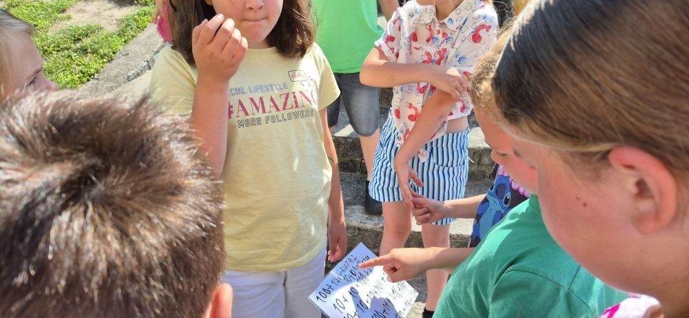 Dziś uczniowie klasy 2b wybrali się na plac przed szkołę, gdzie połączyli przyjemne z pożytecznym. Podczas zabawy w rzuty woreczkiem do celu dzieci nie tylko świetnie się bawiły, ale również ćwiczyły swoją sprawność rachunkową – dodając zdobyte przez grupy punkty.  Radość, ruch i nauka w jednym – właśnie tak lubimy się uczyć.